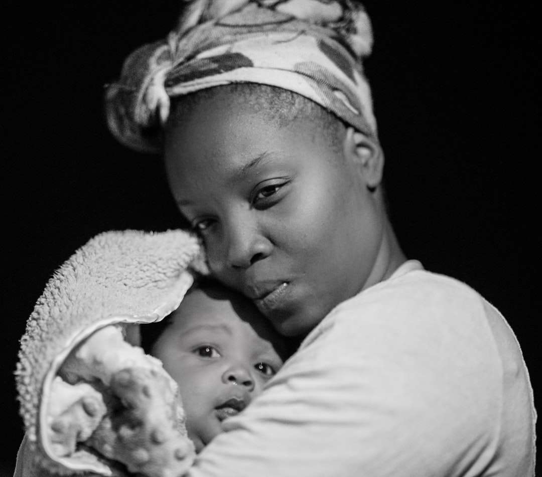 Foto en escala de grises de mujer con bebé rompecabezas en línea