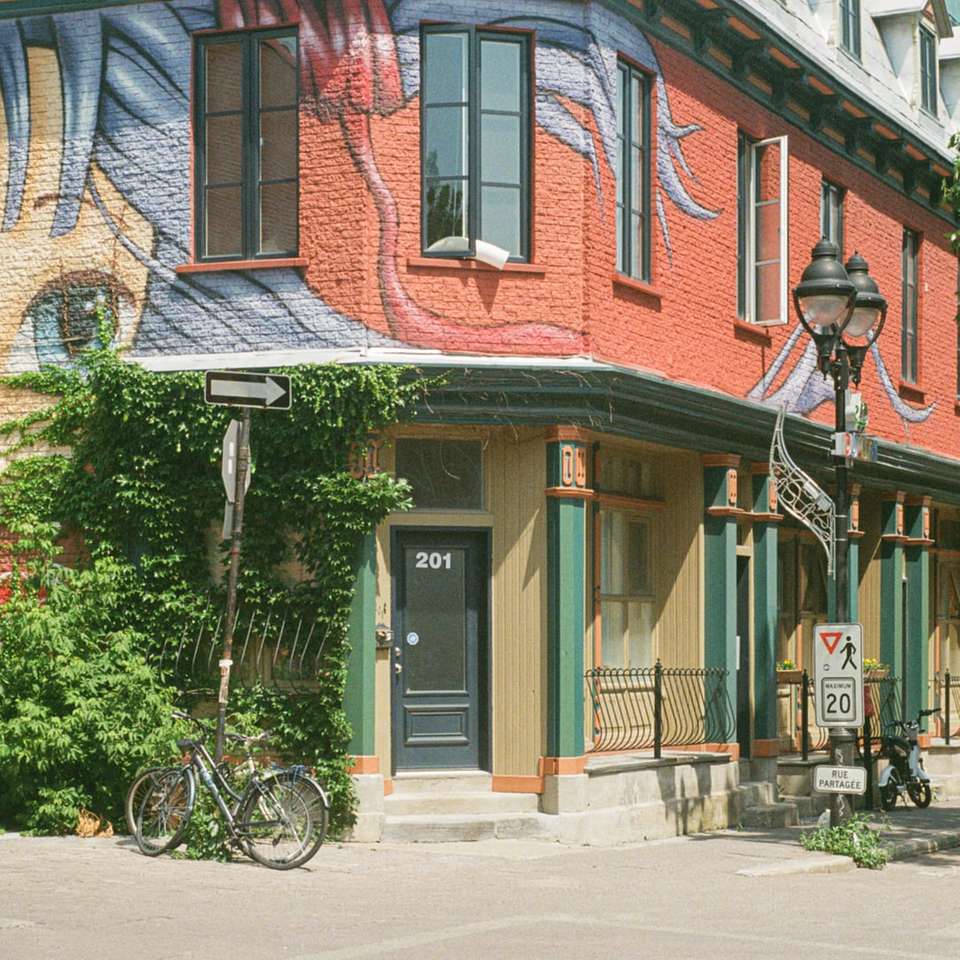 Bicicleta negra estacionada junto a un edificio de hormigón blanco y marrón rompecabezas en línea