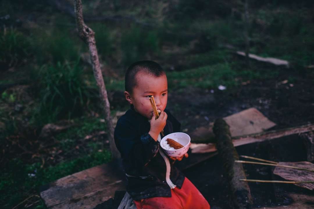 chlapec náušnice jídlo zatímco drží kulatou bílou misku s párem skládačky online