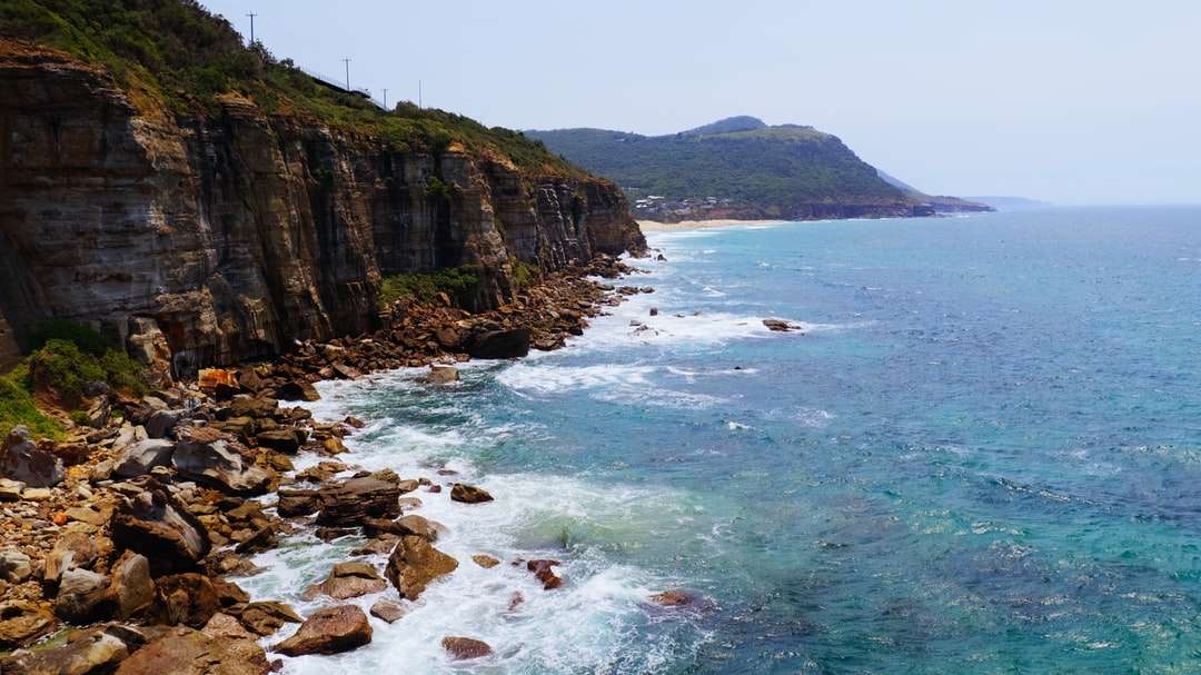 пляжная скала с видом на синее море в дневное время пазл онлайн