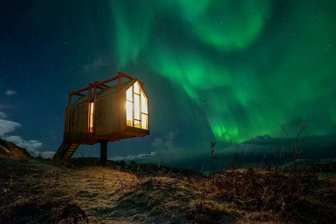 Maison sur pilotis en Scandinavie dans les aurores boréales puzzle en ligne