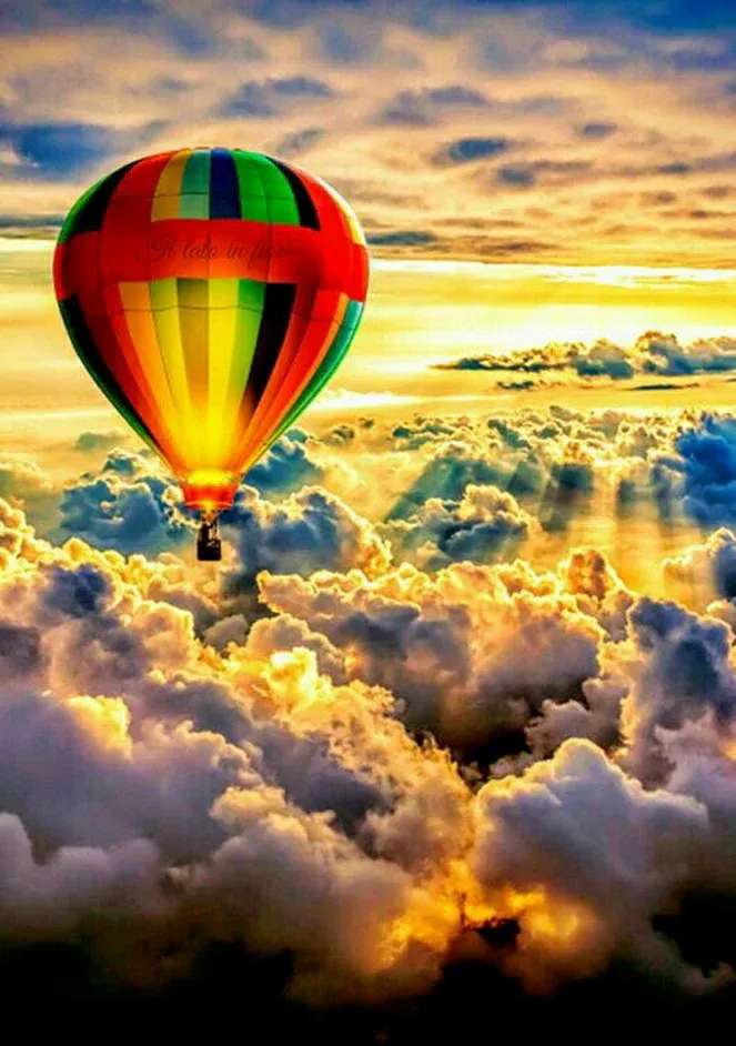 Balon colorat cu aer cald deasupra norilor jigsaw puzzle online