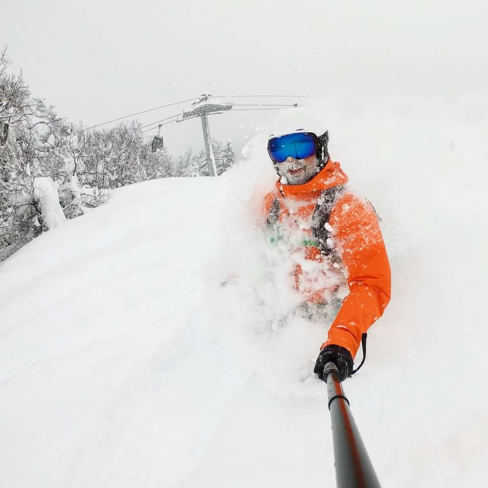 человек в оранжевой куртке на снегу онлайн-пазл