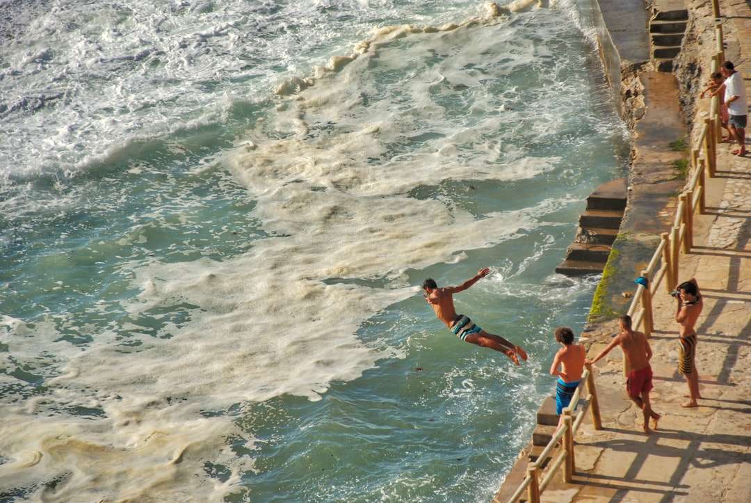 homme sautant sur la mer sur la photographie de mise au point puzzle en ligne