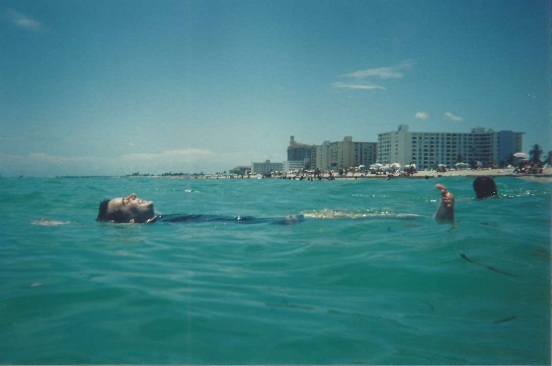 homme en short bleu nageant sur la mer pendant la journée puzzle en ligne