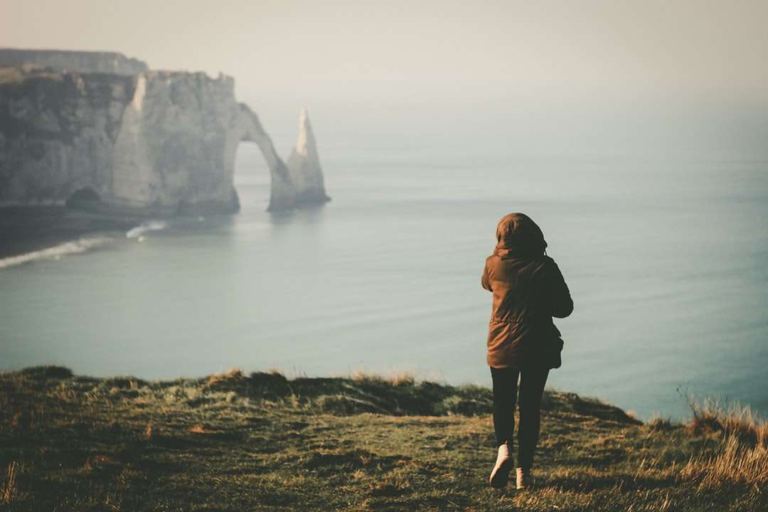 woman walking towards the edge of island facing the ocean online puzzle