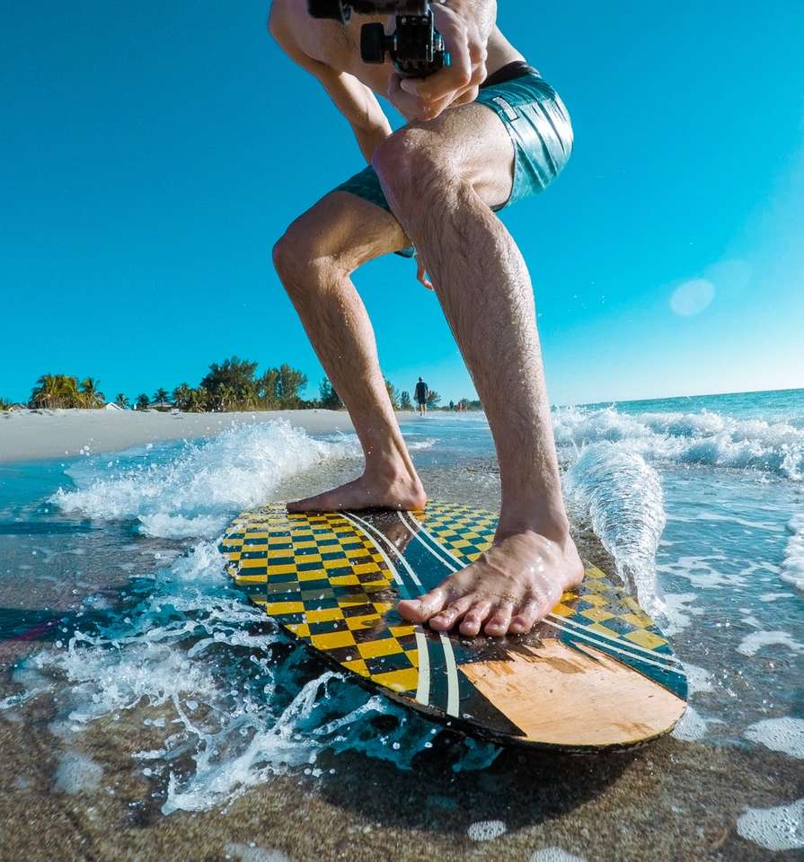 човек, който кара сърф, докато прави кадри от себе си онлайн пъзел