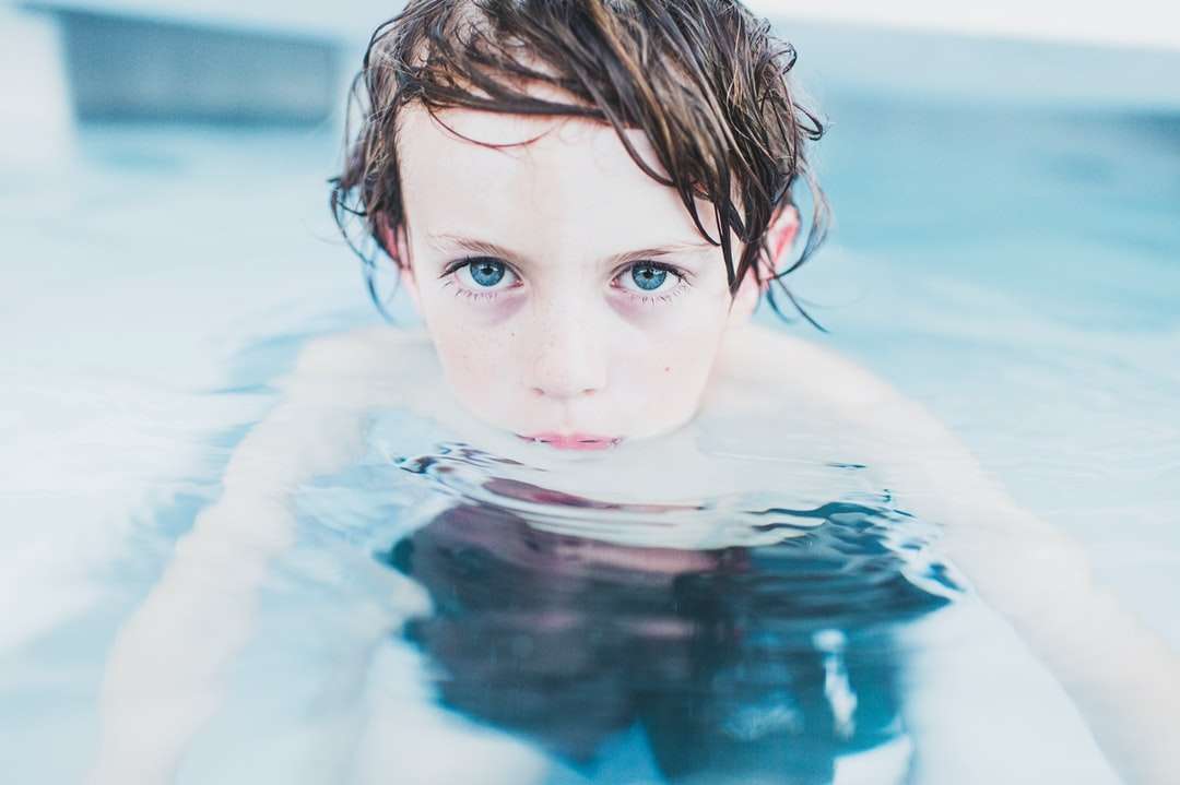 photographie de mise au point sélective de garçon flottant sur l'eau puzzle en ligne