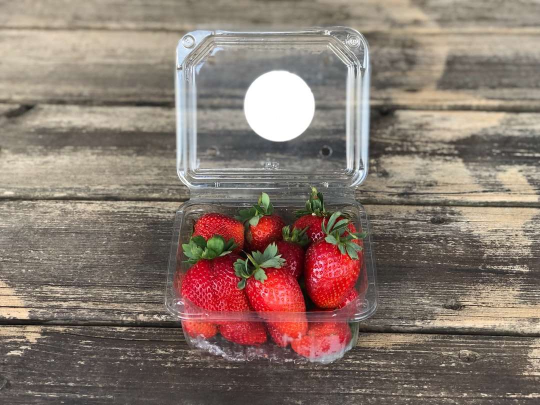 Packung Erdbeeren auf brauner Holzoberfläche Online-Puzzle
