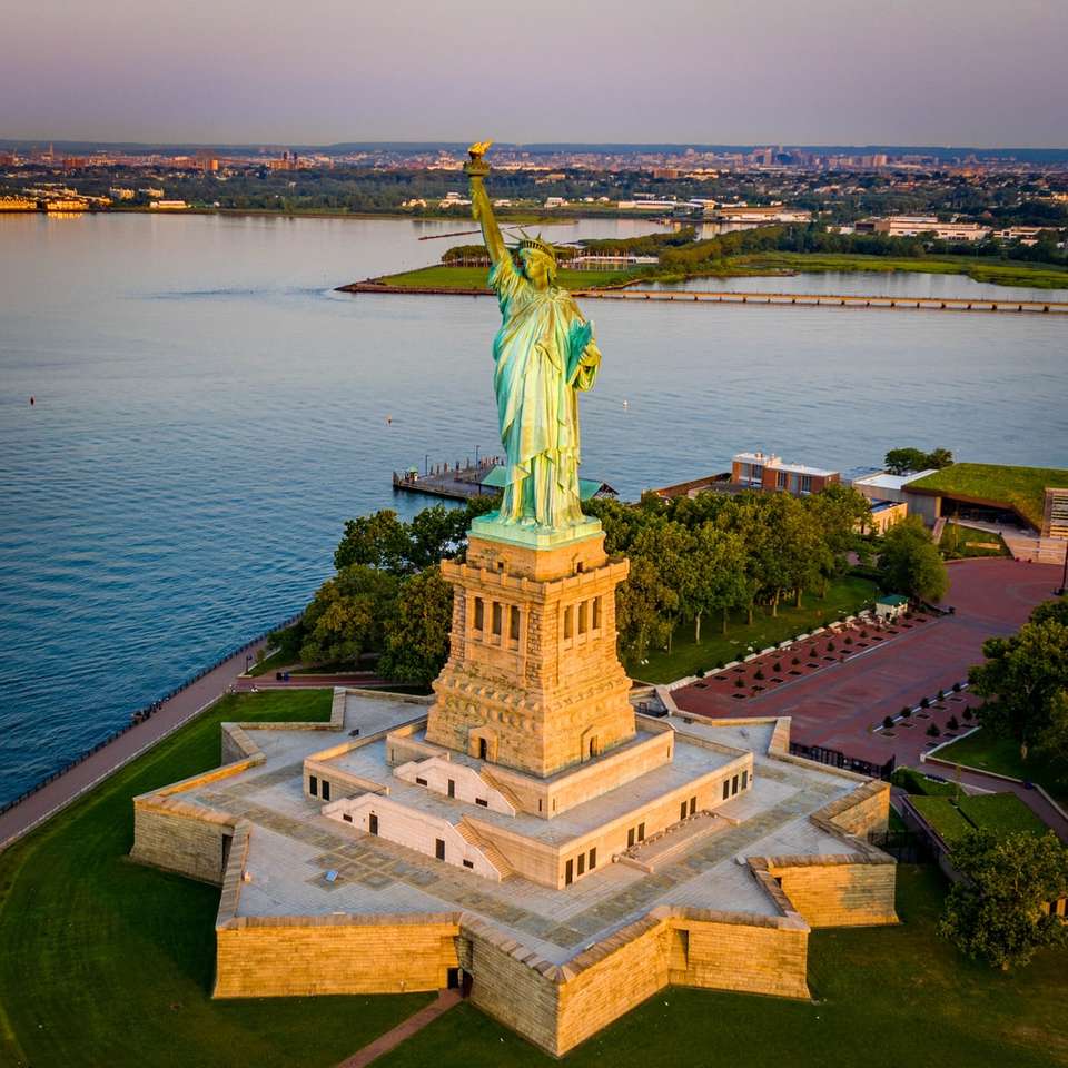 socha svobody poblíž vodní plochy během dne online puzzle