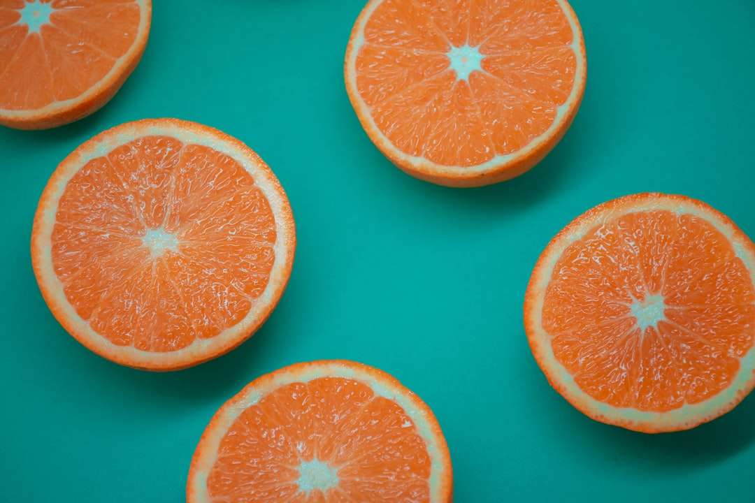 нарізані помаранчеві фрукти на синій поверхні пазл онлайн