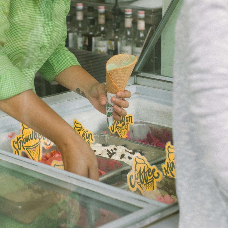 osoba, která drží zmrzlinový kornout a nabírá zmrzlinu skládačky online