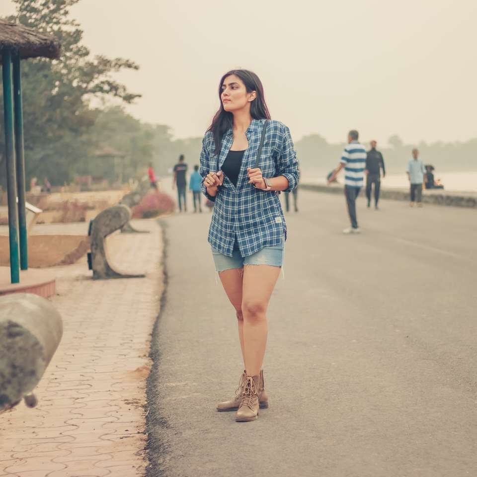 женщина в черно-белой рубашке с длинным рукавом стоит на дороге пазл онлайн
