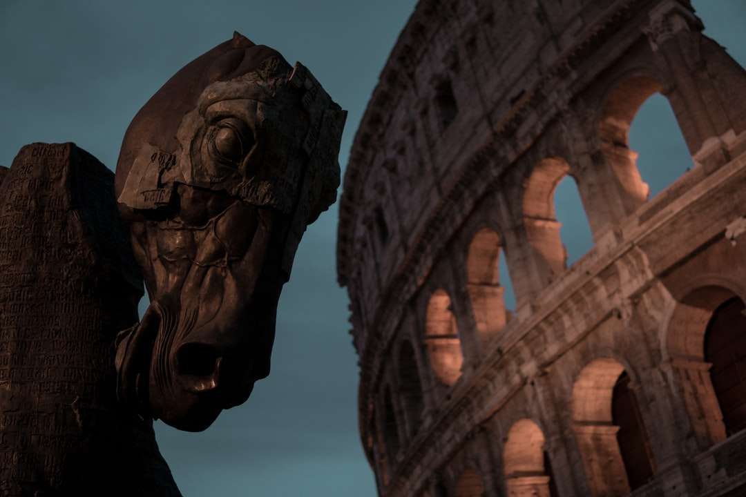 brun trähästhuvudskulptur bredvid Colosseum Pussel online