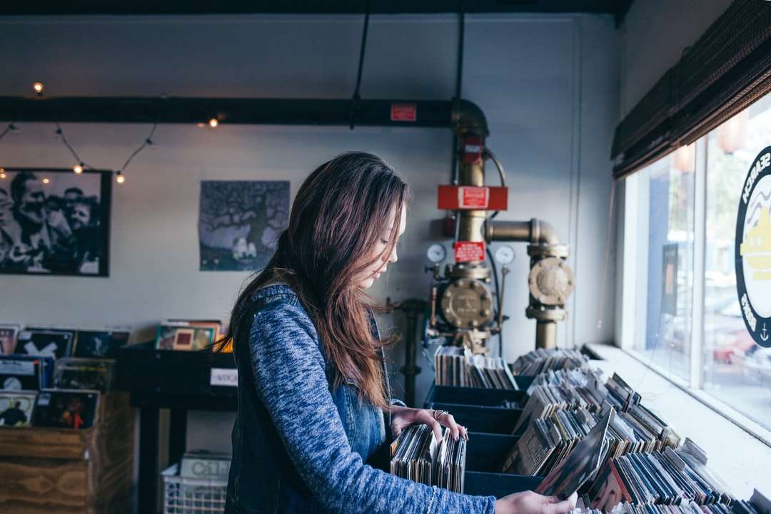 mulher em pé na prateleira de manga estéreo segurando uma manga quebra-cabeças online