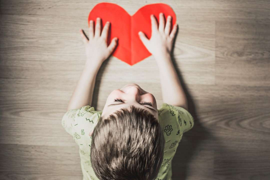 αγόρι σε πράσινο πουκάμισο κρατώντας κόκκινο χαρτί καρδιά διακοπής παζλ online