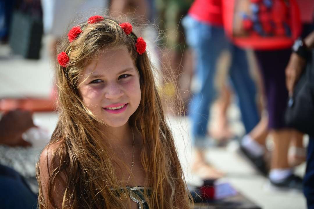 χαμογελαστό κορίτσι με κόκκινο λουλούδι κόμμωση online παζλ