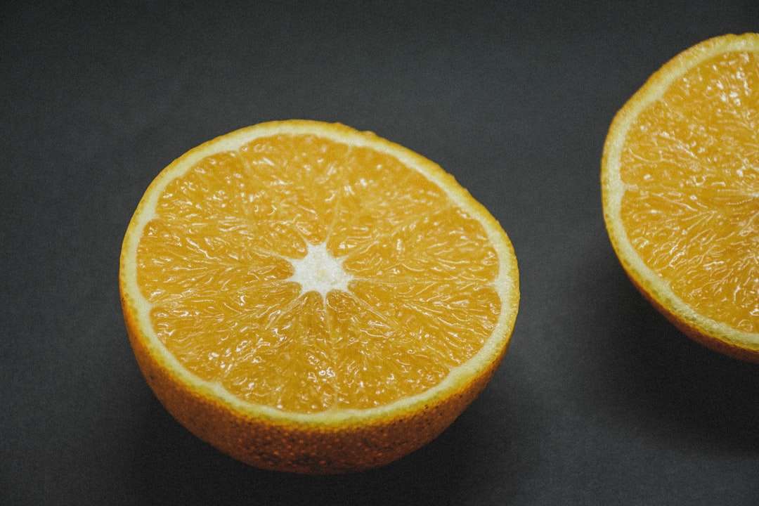 нарязан портокалов плод върху черен текстил онлайн пъзел