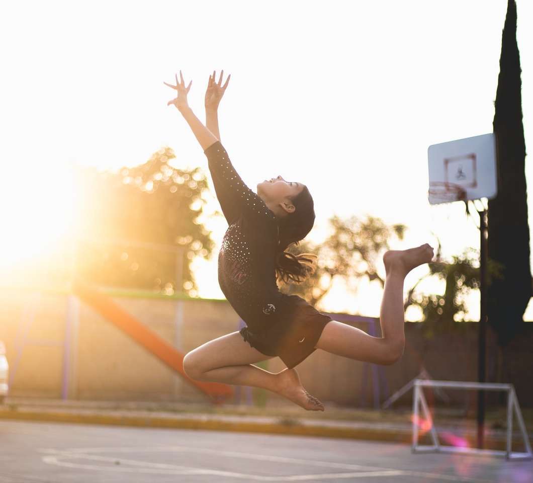 mulher de camiseta preta e legging preta pulando puzzle online
