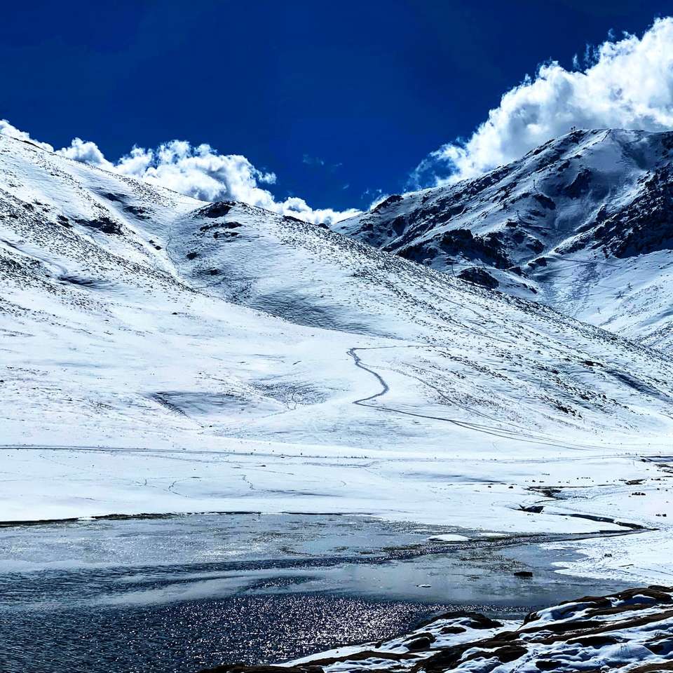 montanha coberta de neve sob céu azul durante o dia quebra-cabeças online