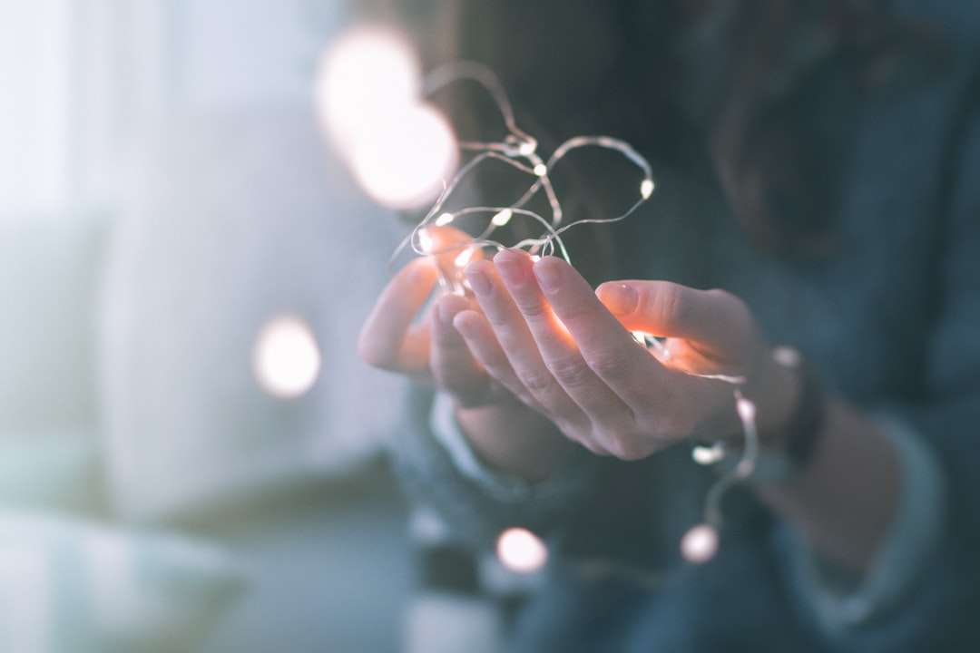 fotografia de foco raso de pessoa segurando luzes de corda puzzle online