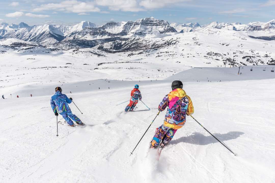 Двама души в жълто яке и синя каска за каране на ски остриета онлайн пъзел