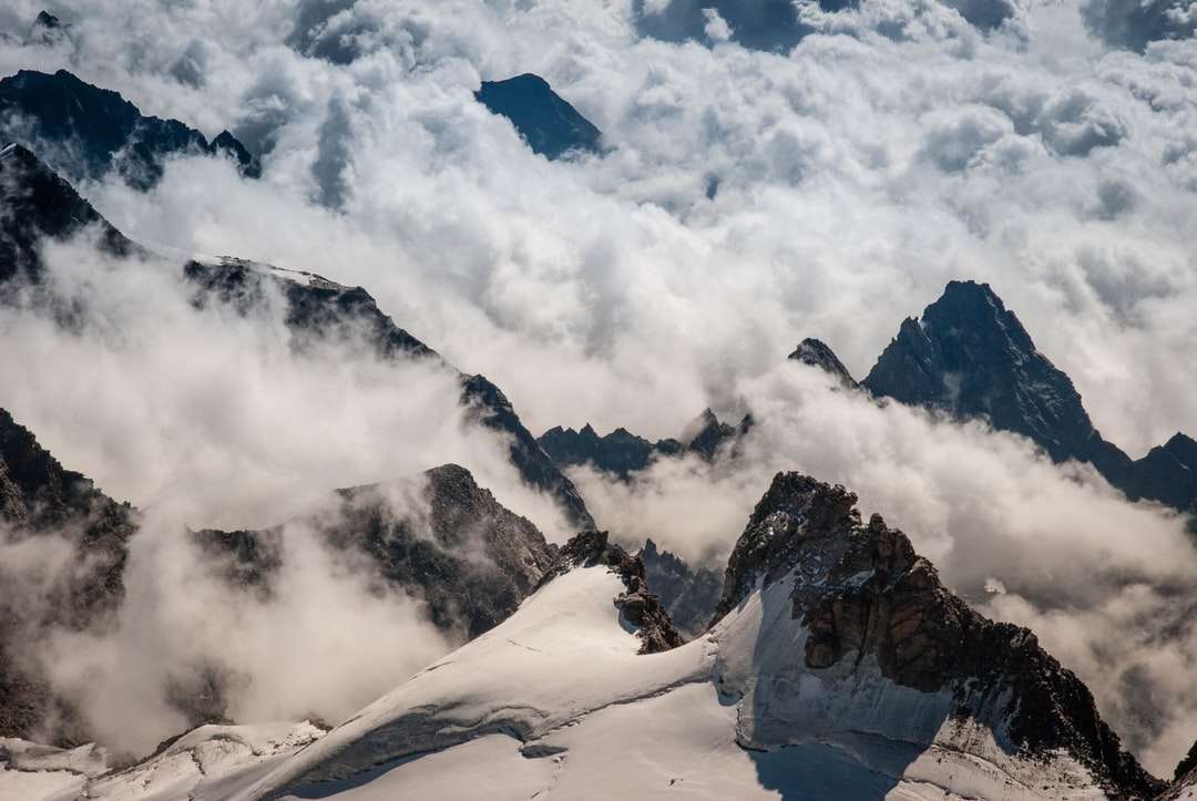 Flygfoto över berg täckta med moln Pussel online