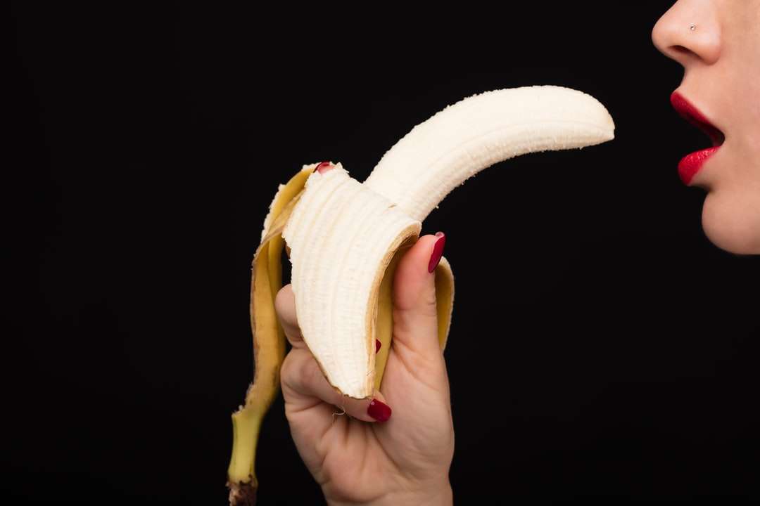 persona sosteniendo fruta de plátano amarillo rompecabezas en línea