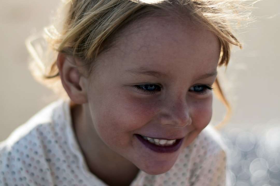 Foto de enfoque selectivo de joven niña sonriente rompecabezas en línea