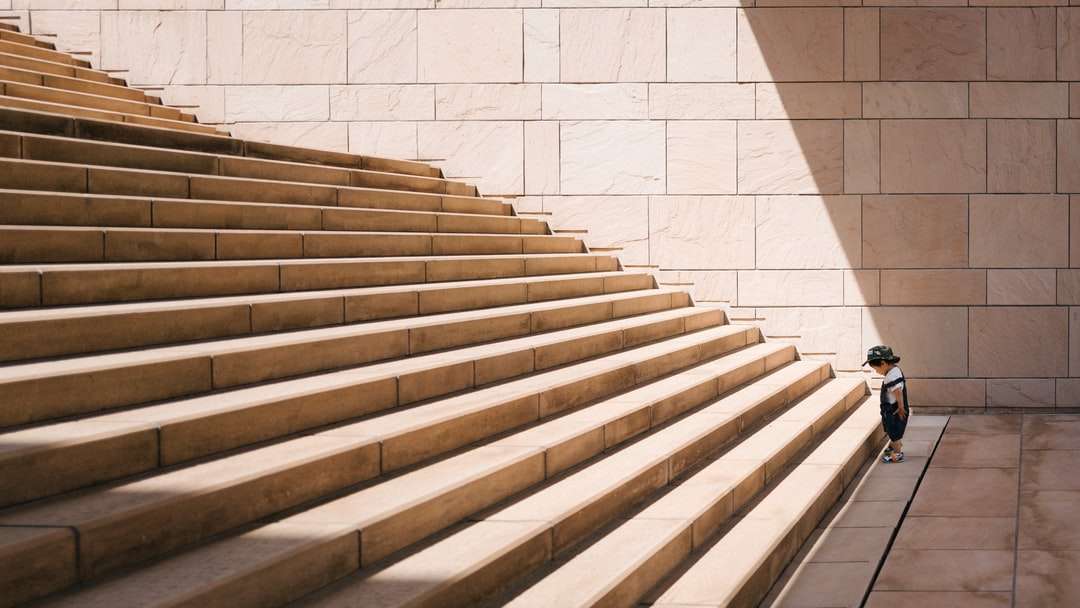 peuter staat voor beige betonnen trap legpuzzel online