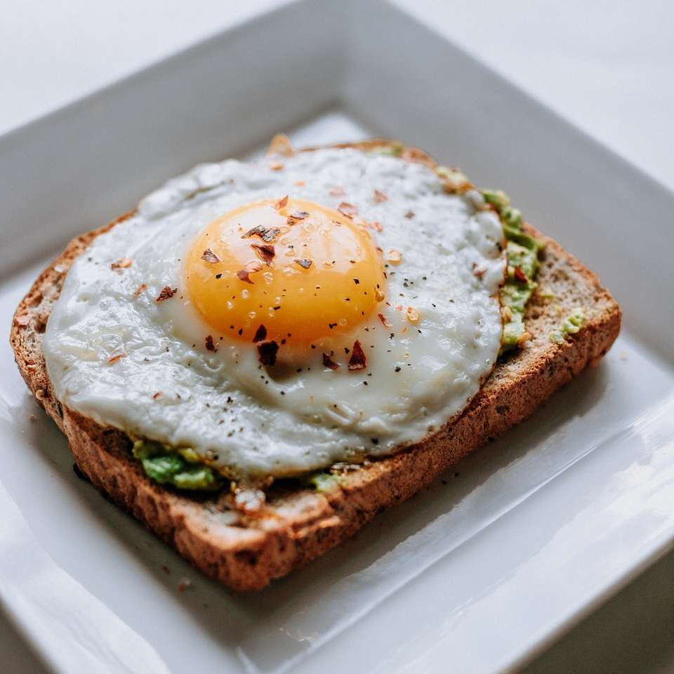 chléb se sluncem nakloněným vejcem podávaný na bílé keramické desce skládačky online