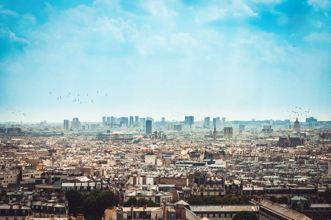 Fotografía aérea de la ciudad bajo las nubes blancas y el cielo azul. rompecabezas en línea