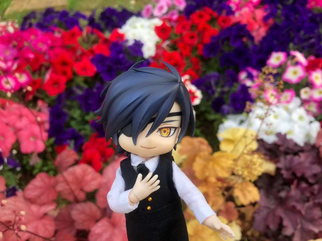 Mitsu framför en blomsterrabatt pussel på nätet