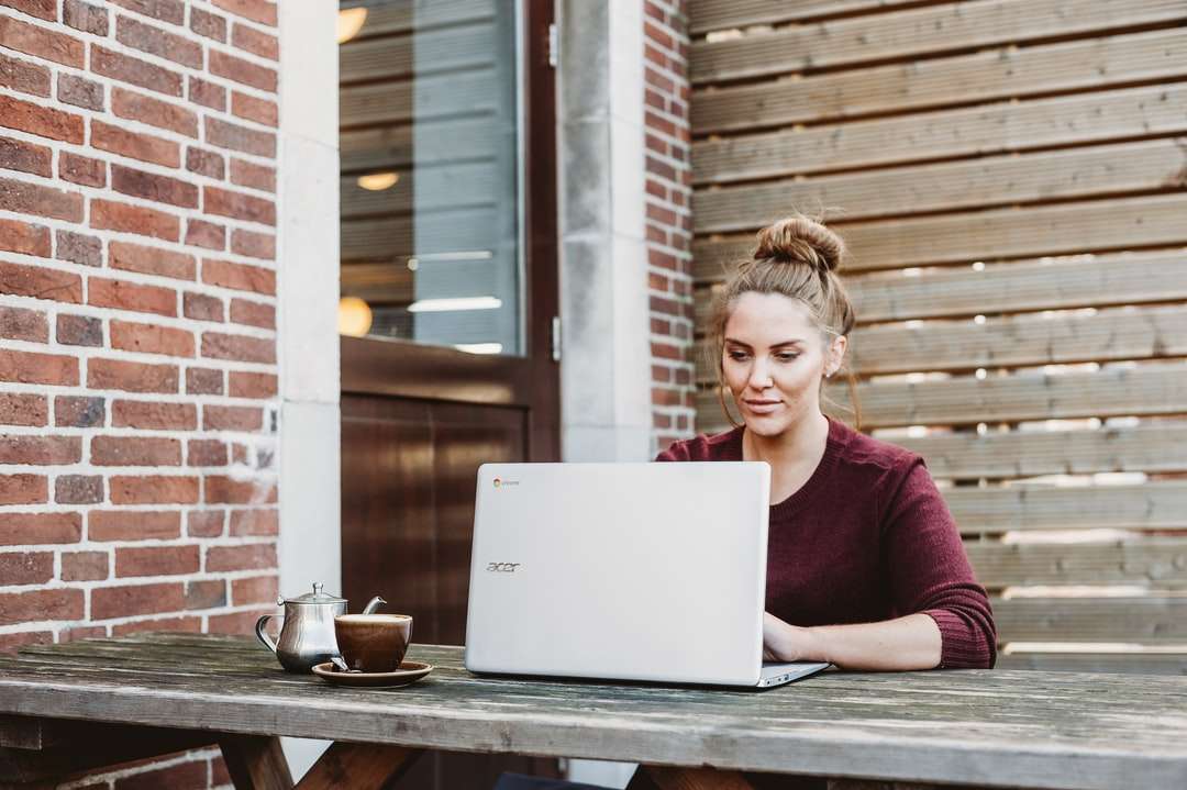 Mujer sentada y sosteniendo portátil Acer blanco rompecabezas en línea