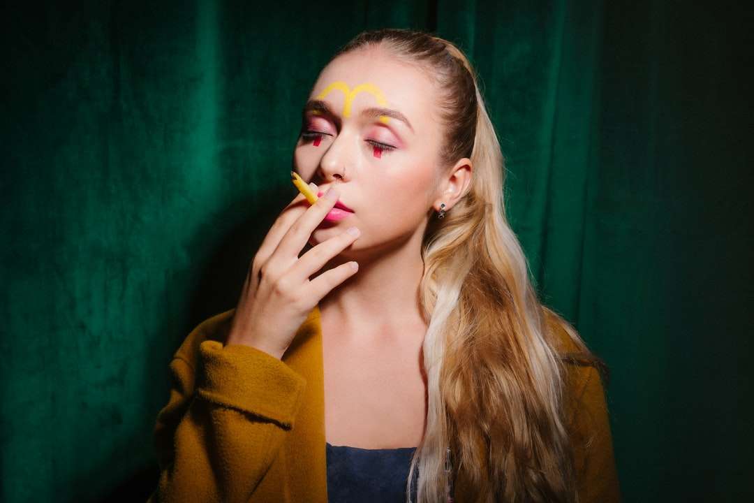 жінка в жовтому кардигані курить сигарету онлайн пазл