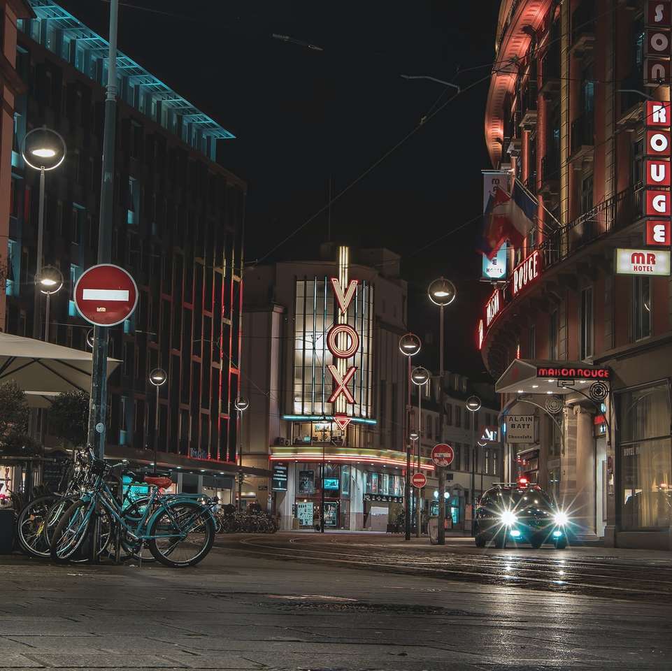 улица в ночное время с велосипедом, припаркованным на обочине пазл онлайн
