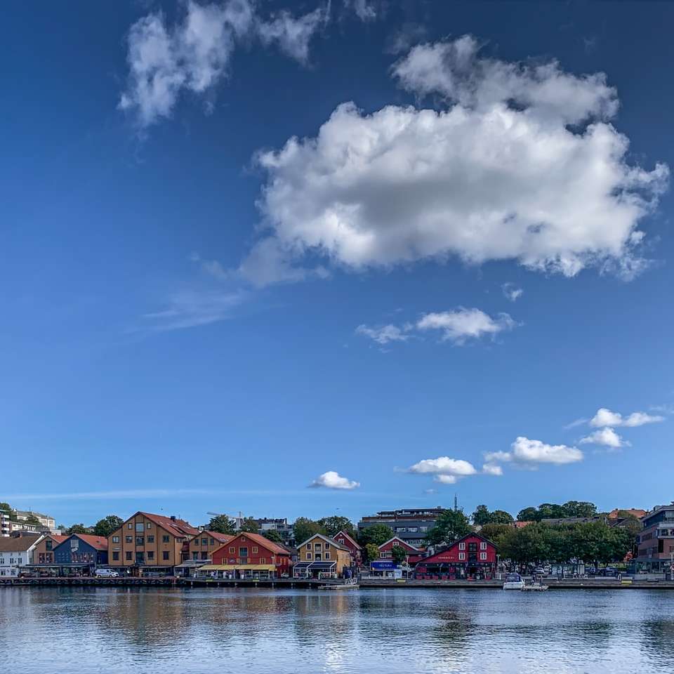 bruin houten huis op waterlichaam onder blauwe hemel online puzzel