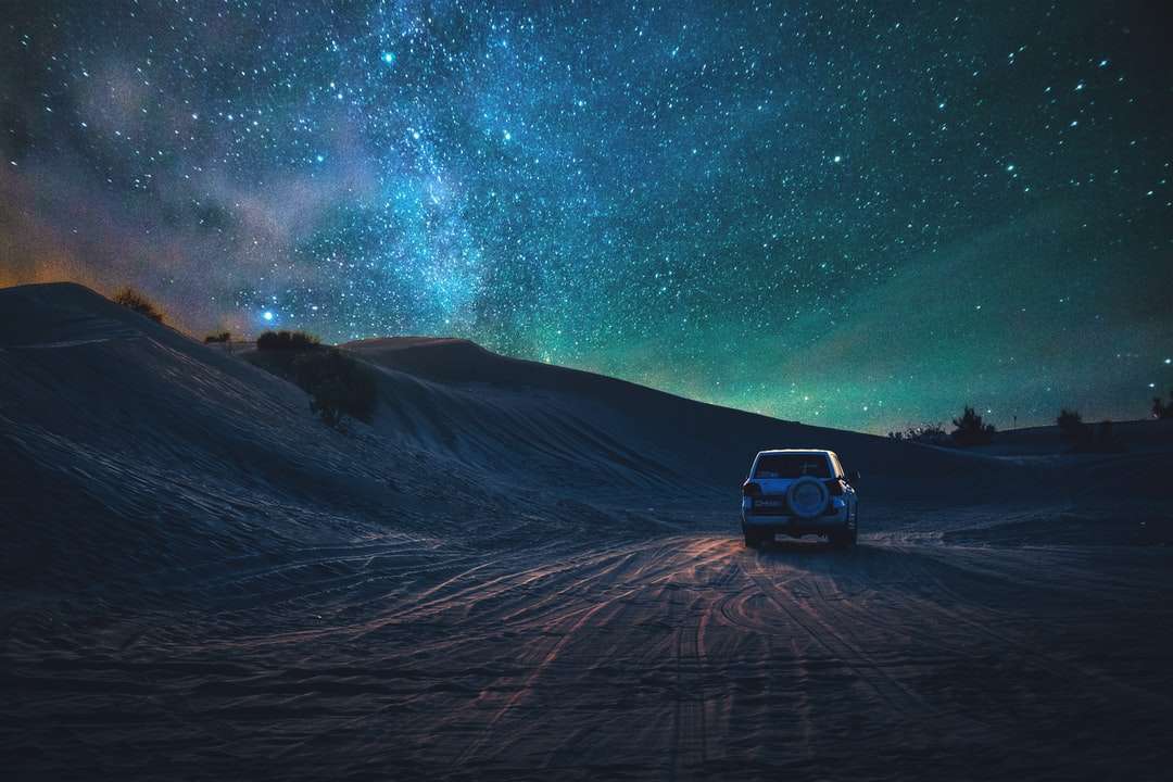 сірий транспортний засіб, що подорожує по пустелі в нічний час пазл онлайн