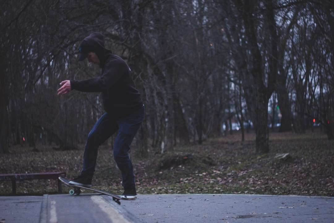 man in zwarte jas en blauwe denim jeans rijden skateboard legpuzzel online