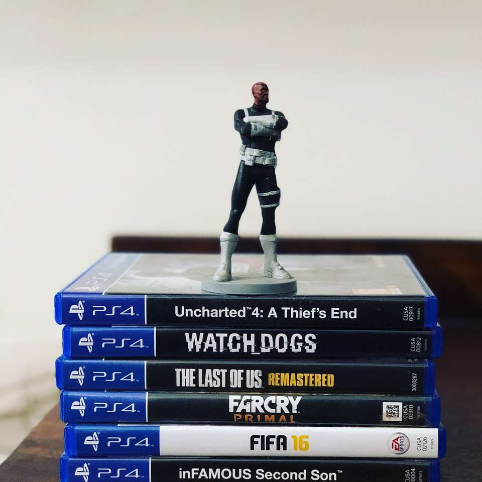 assorted-title Sony PS4 game cases with figurine on top online puzzle