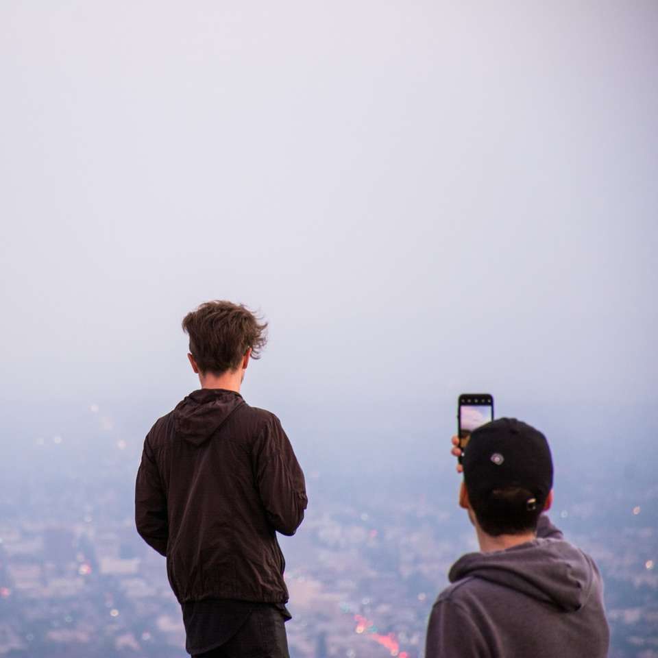 Hombre tomando una foto de una ciudad durante la niebla rompecabezas en línea