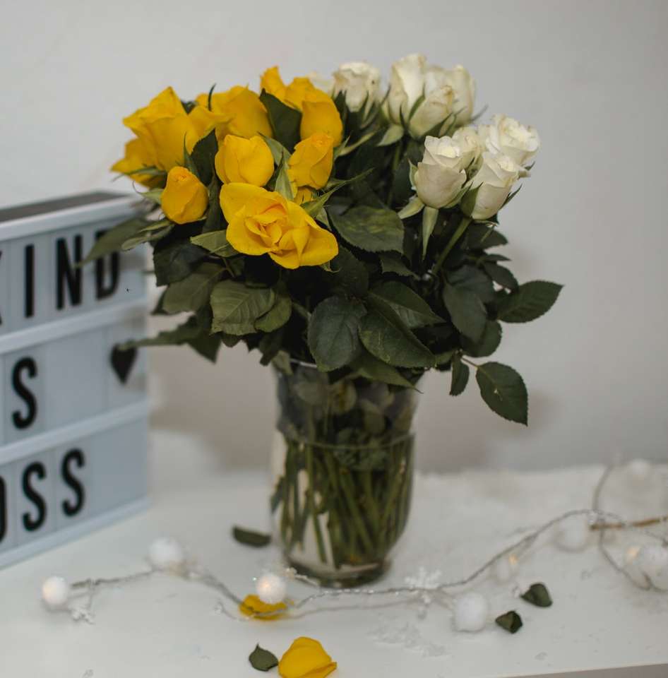 κίτρινα λουλούδια σε διαφανές γυάλινο βάζο σε λευκό χιόνι παζλ online
