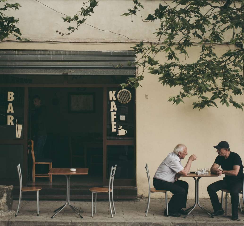 zwei Mann plaudern weiß sitzen auf braunem Holzstuhl Online-Puzzle