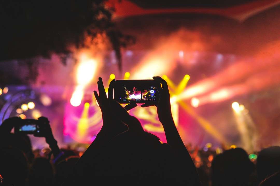 човек, който държи смартфон, заснема видео на концерт онлайн пъзел