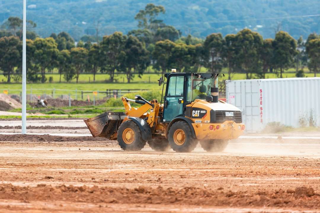 yellow and black front loader on brown soil during daytime jigsaw puzzle online
