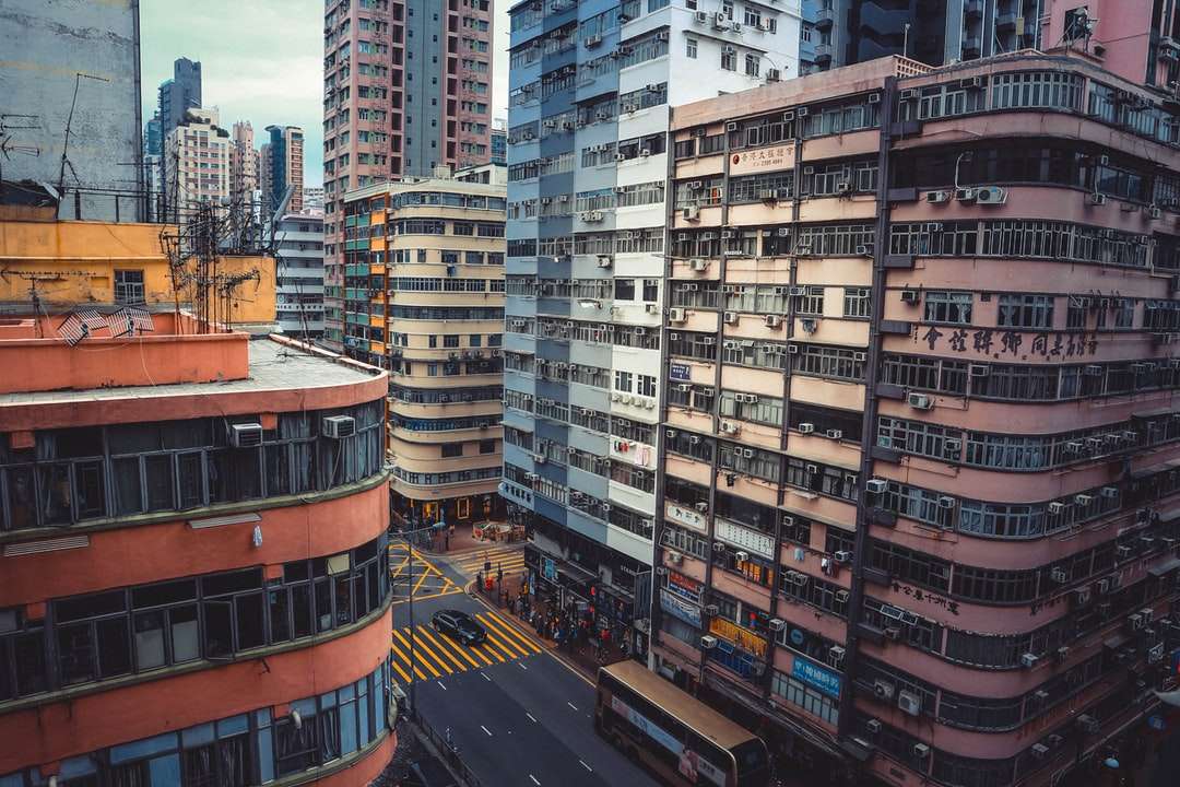 Menschen überqueren die Straße in der Nähe von braunen Betongebäuden Online-Puzzle