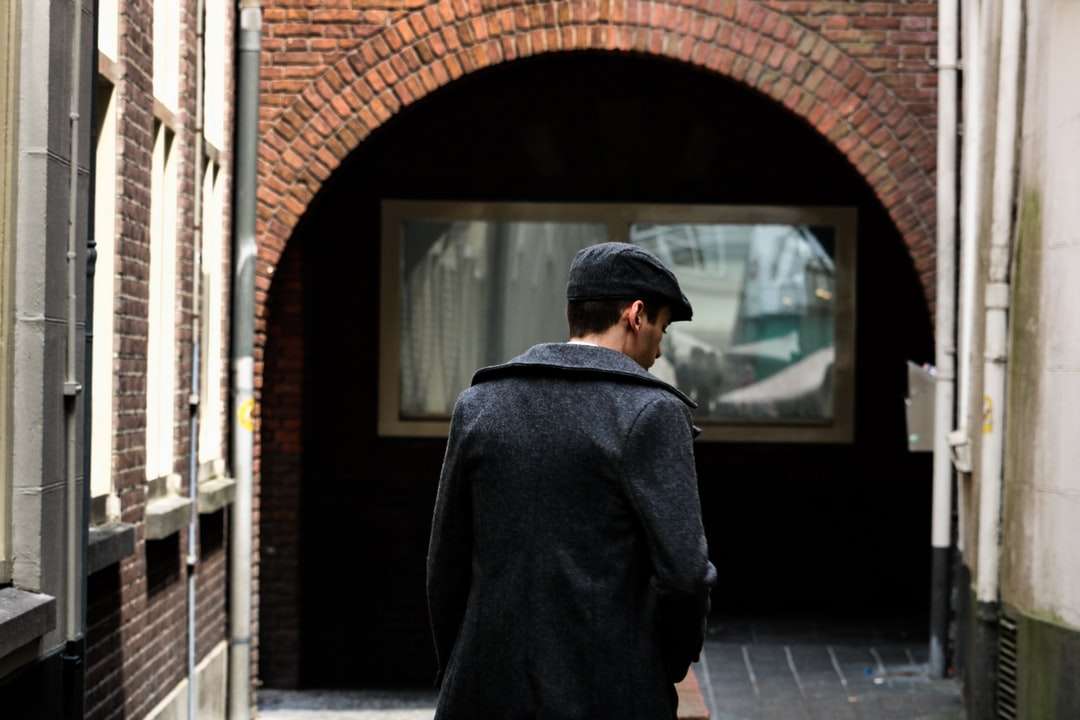 човек, който се разхожда по улицата близо до бялата сграда онлайн пъзел