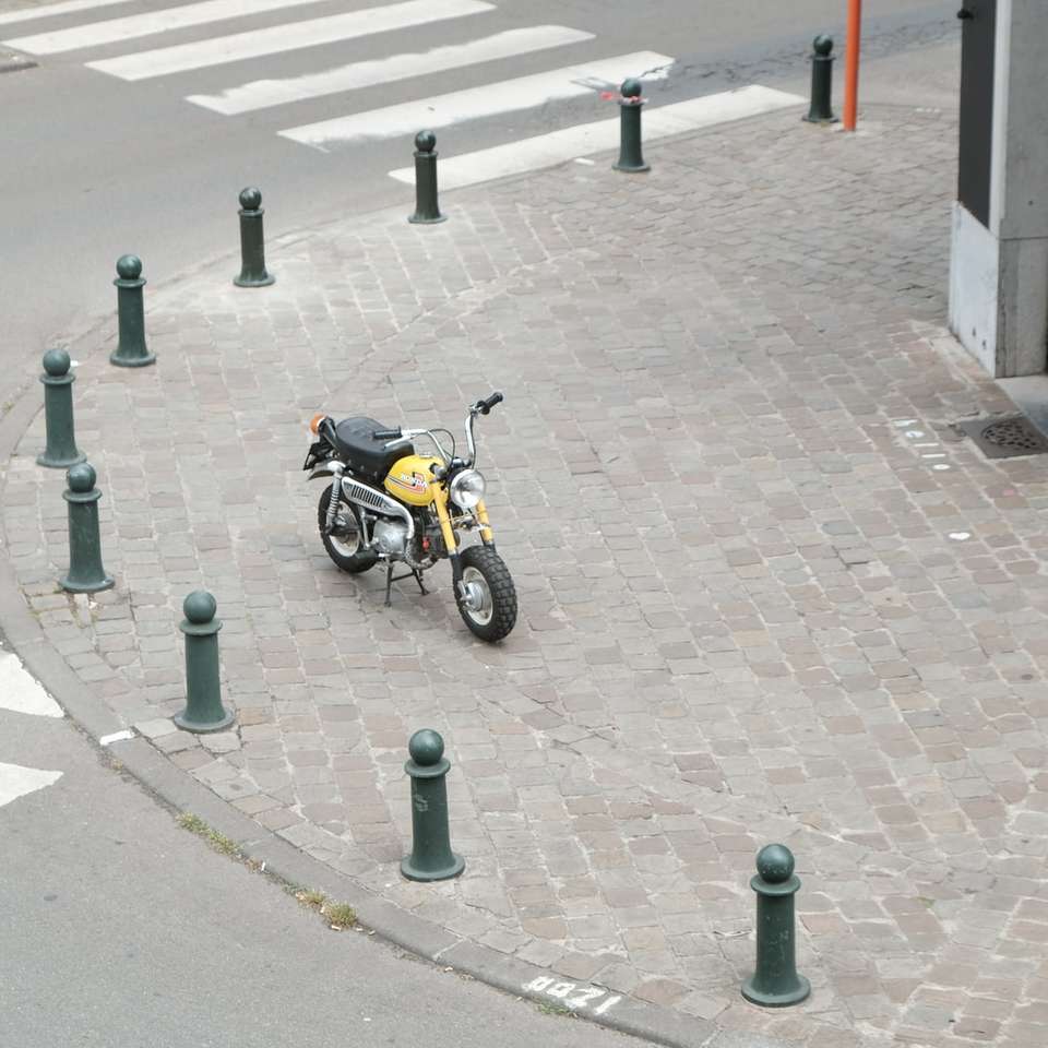 tagsüber auf dem Bürgersteig geparktes schwarzes Motorrad Puzzlespiel online