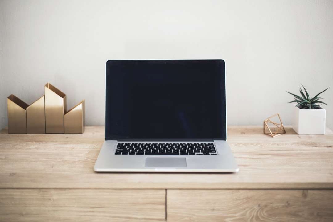 MacBook Pro a barna asztal tetején online puzzle