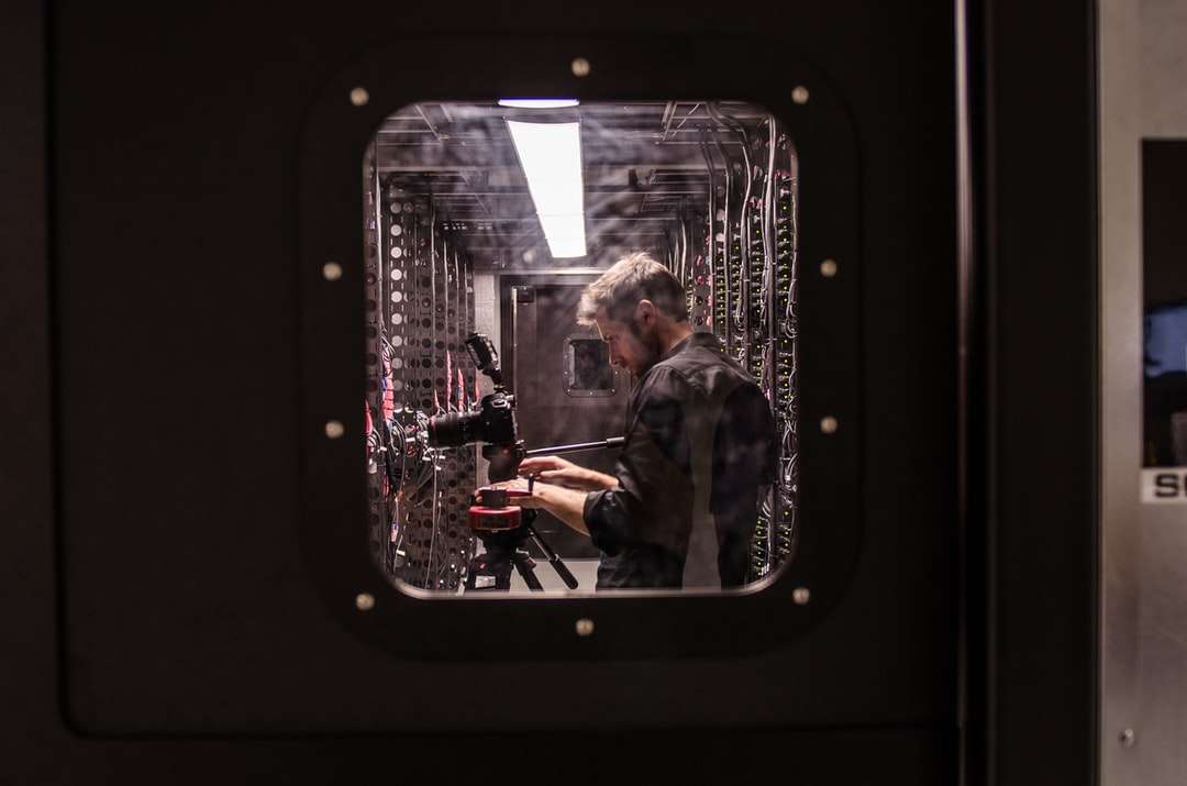 homem segurando uma câmera DSLR preta quebra-cabeças online
